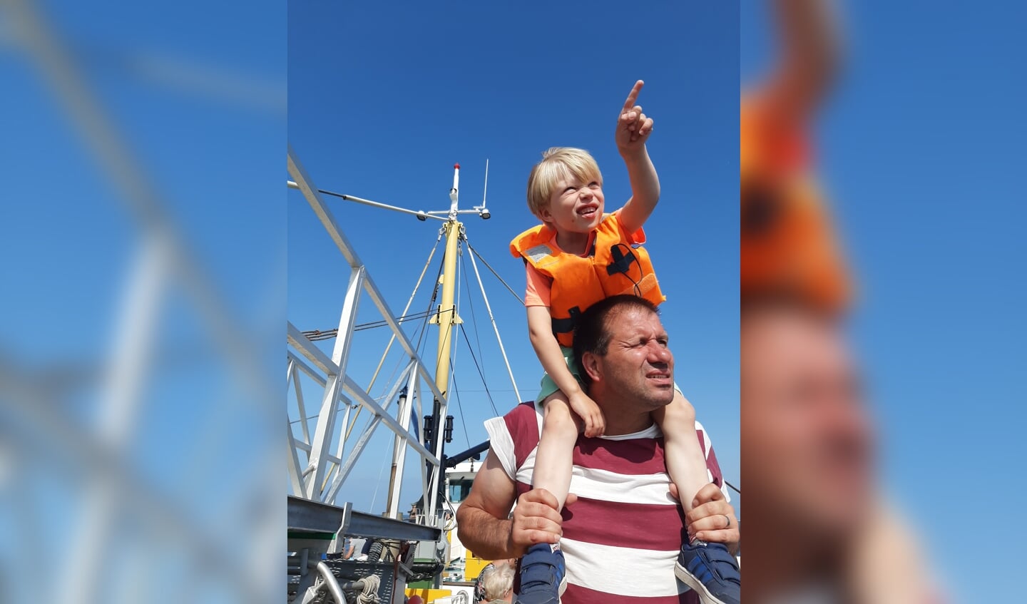 Op de foto staan Yavi en zijn papa. Ze zijn op de boot op Texel. Yavi spot een zeehond in de verte.