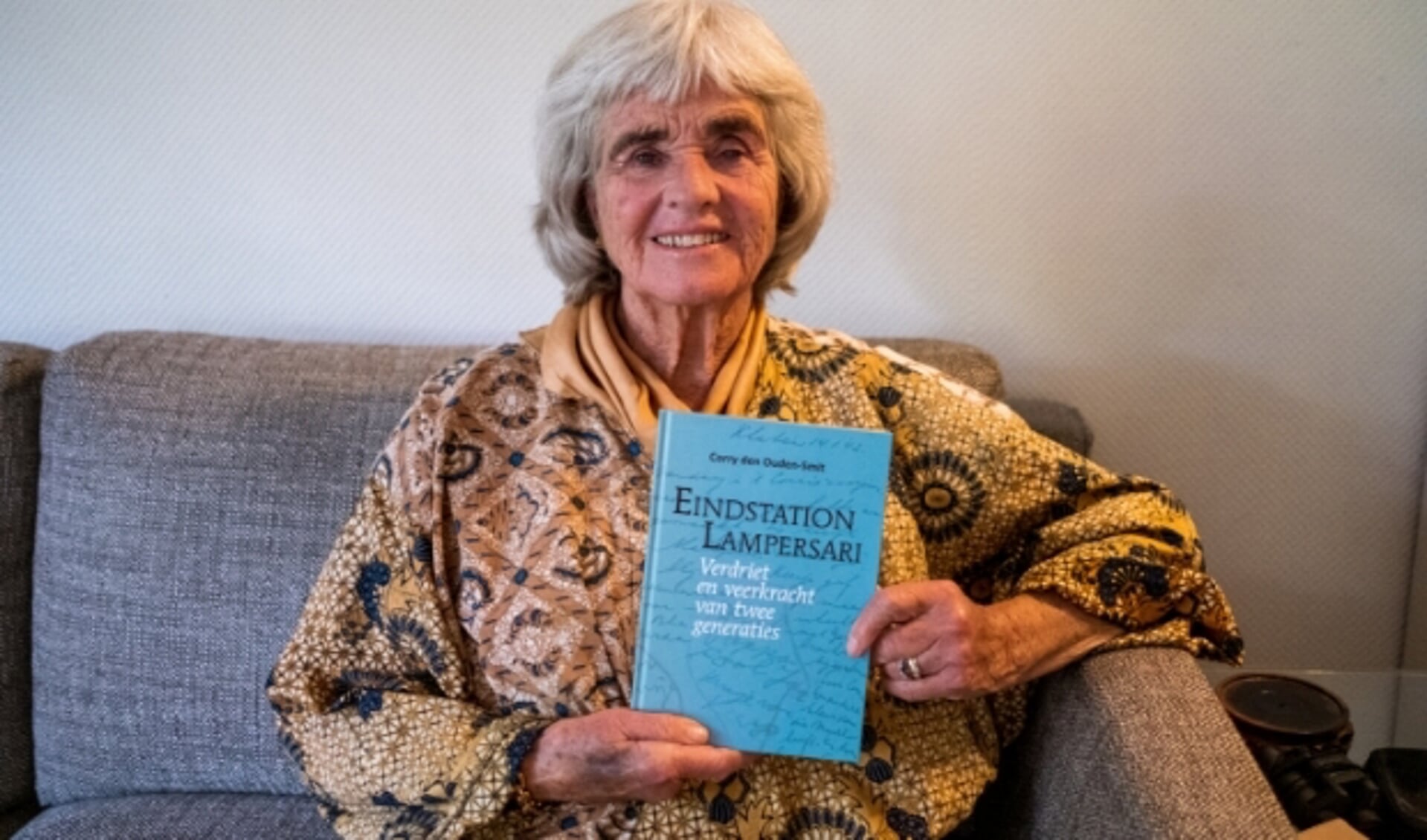 Corry den Ouden-Smit met haar boek 'Eindstation Lampersari' dat in de boekhandel van Bilthoven te koop is