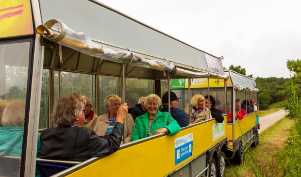 <p>Deelnemers en vrijwilligers genieten volop in het treintje in de duinen rond Schoorl</p>
