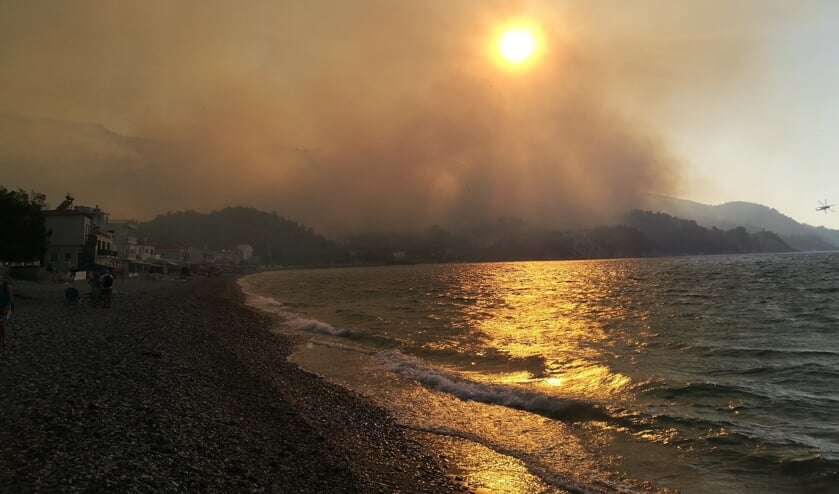 "Smokey sun" ,,Gevlucht vanaf een klein strandje via een bosweg vol rook en nog bijkomend van plotselinge evacuatie, alles achterlatend, kijk ik naar 'mijn' appartement hoog in de heuvels... Een 3-daags evacuatie avontuur maar na ruim 2 jaar wachten ook slechts een "luxeprobleempje" van mijn heerlijke griekse vakantie! Kokkari, Samos 15 juli 2021."