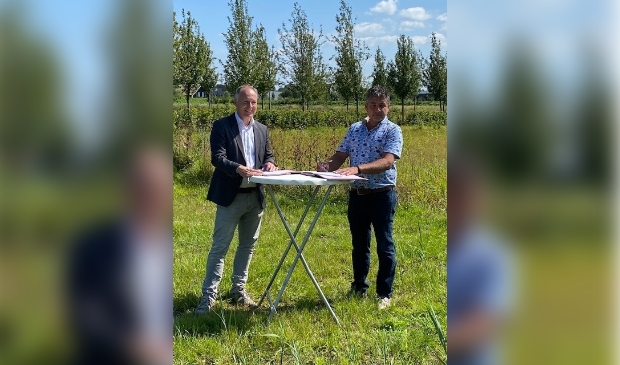 <p>Wethouder Kiel (links) en Gerrit Wernsen zetten onder stralende omstandigheden hun handtekening onder de overeenkomst die voor het bedrijf een even stralende toekomst moet inluiden.</p>