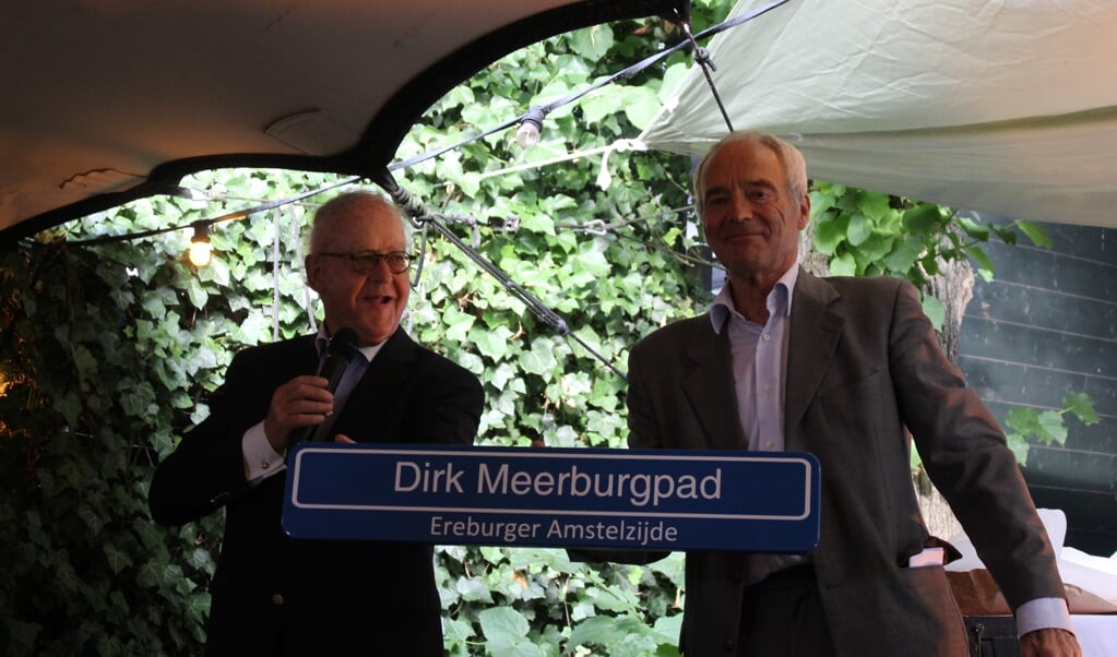 Mr Dirk Meerburg (rechts) ontvangt zijn 'ereburgerschap' uit handen van Otto Over, bewoner Amstelzijde. 