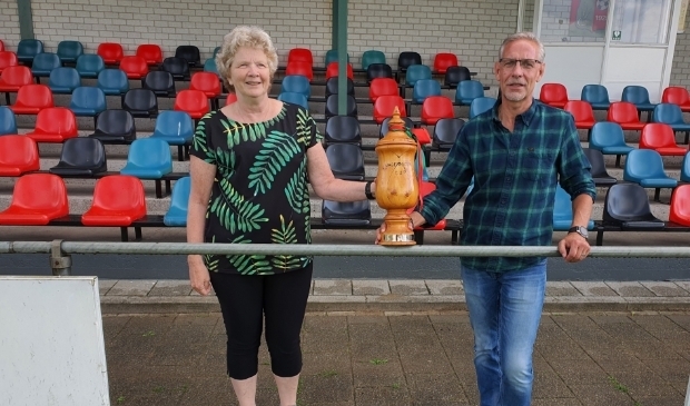 <p>Anita Jochems en Tonnie Bongers poseren met de oorspronkelijke houten Wageningen Cup. </p>