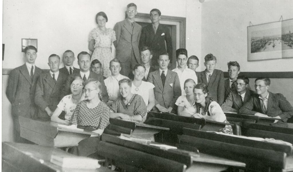Groepsfoto uit 1933 van klas c van de Rijks HBS aan de Kalkhaven met directeur dr. M.O. Albers. De foto is gemaakt in een leslokaal.