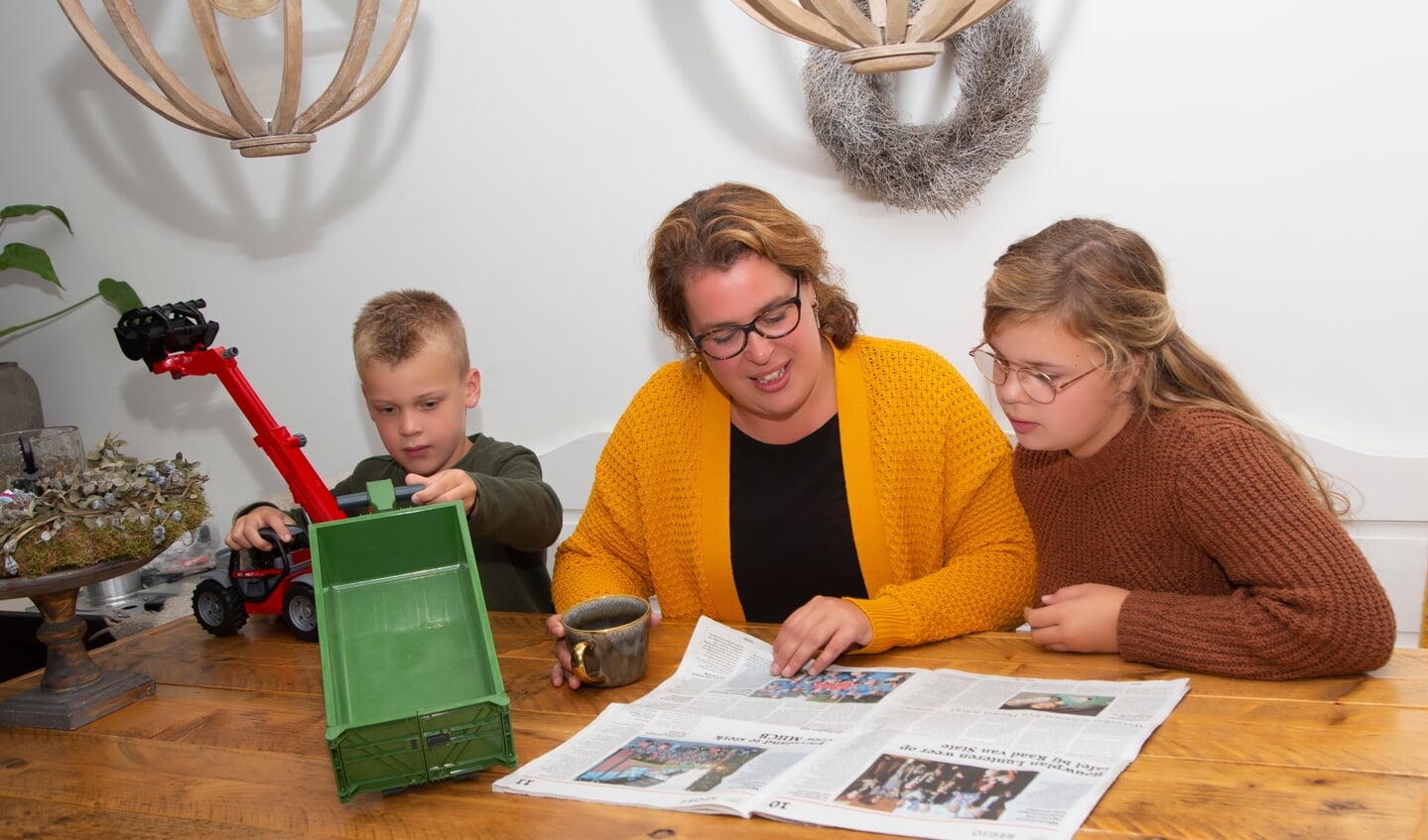 Anne Heij leest de krant aan de keukentafel, deze keer in het bijzijn van dochter Rosanne en zoon Tim.