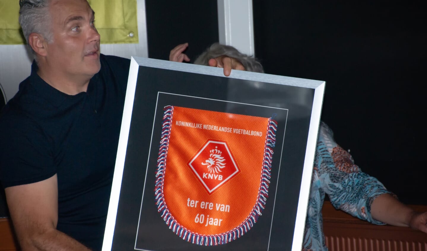 Clubvoorzitter Michel van Raaij met het cadeau van de KNVB.