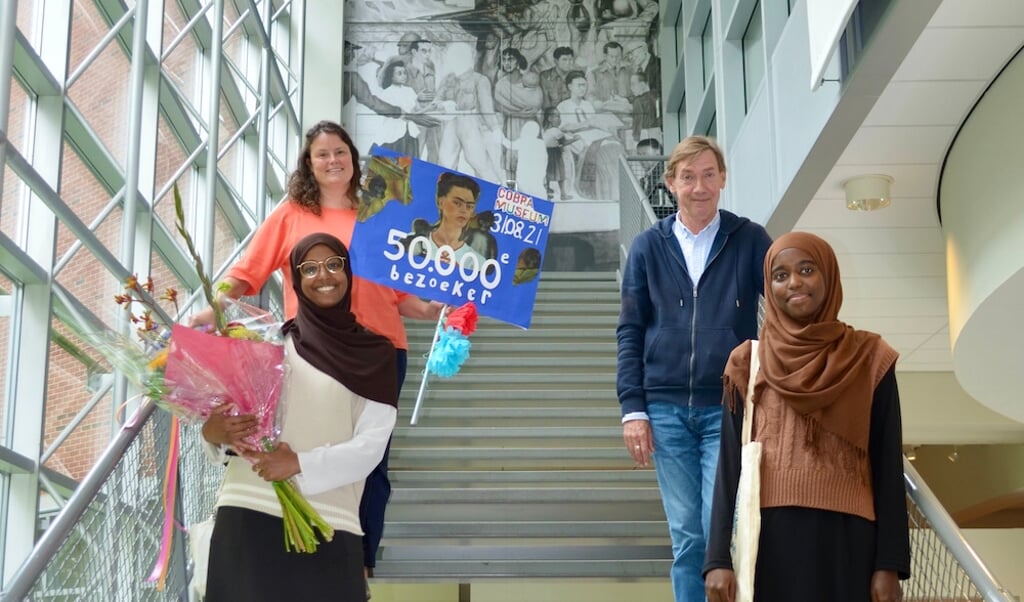 Mamtaz en Khadija ontvingen als 50.000ste bezoekers uit handen van Stefan van Raay een bos bloemen en een goodiebag met de tentoonstellingscatalogus.