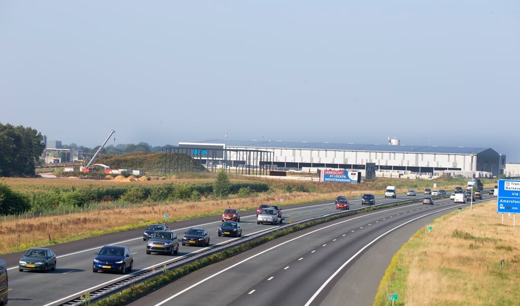 Snelweg A1 ter hoogte van Barneveld, met op de achtergrond bedrijventerrein Harselaar.