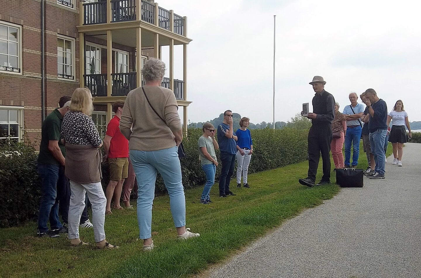 Bezoekers op de Altenawal met (niet zichtbaar) Slot Loevestein op de achtergrond en het verhaal over Hugo de Groot
