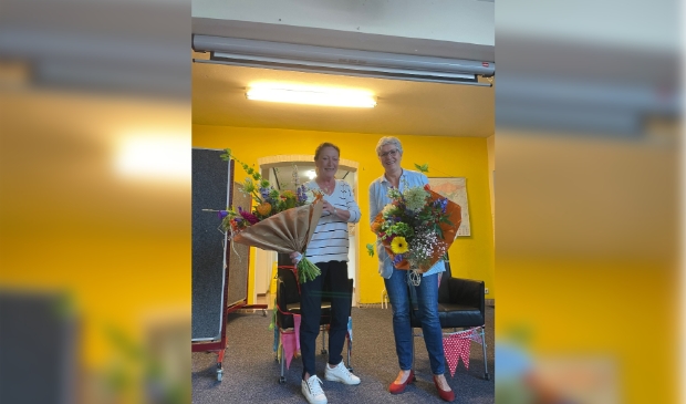 Juf Geeke (links) en juf Ria (rechts) krijgen een bos bloemen vanwege het feit dat zij 40 jaar werkzaam zijn in het onderwijs