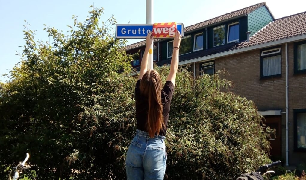 Een Greenpeace vrijwilliger verandert Gruttoweide in GruttoWEG om aandacht te vragen voor de bedreigde Nederlandse natuur