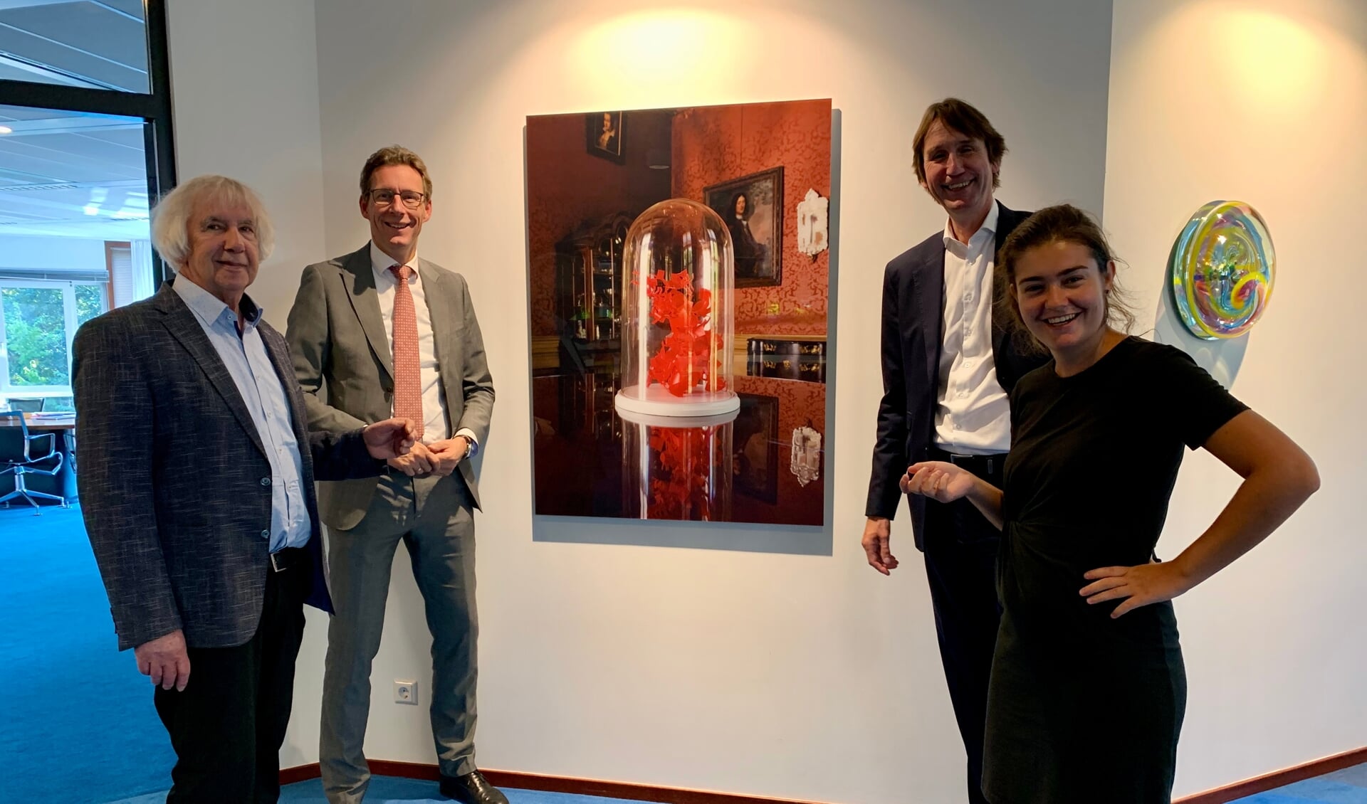 Jan Verschoor, burgemeester Tjapko Poppen. wethouder Herbert Raat en beleidsadviseur Fleur Albers bij een van de foto's in het raadhuis.