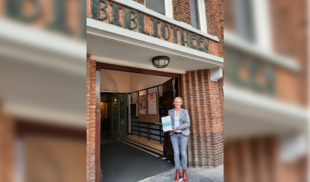 Directeur / bestuurder Miranda van Ooijen met het certificeringsbord dat een plekje krijgt in de Bibliotheek