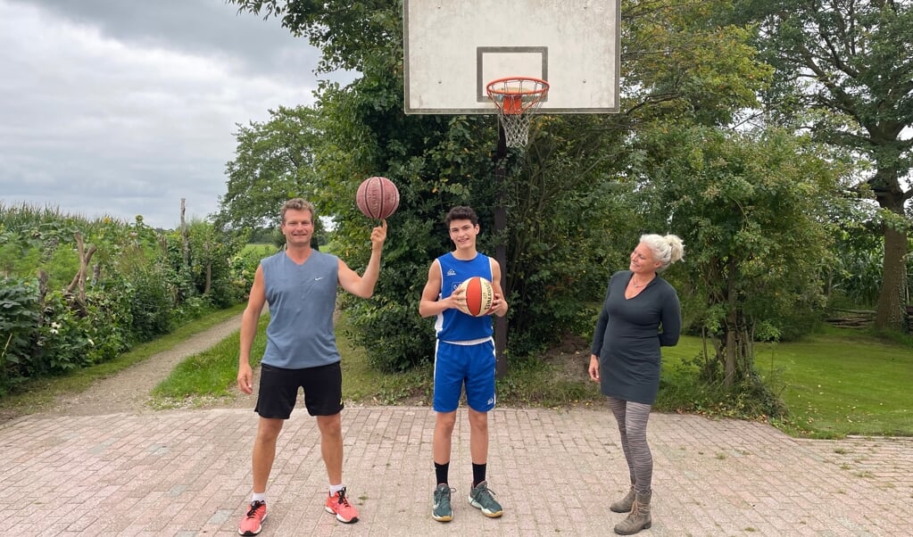 Roelof, Raaf en Marijke Roelofsen op het basketbalpleintje bij hun huis.