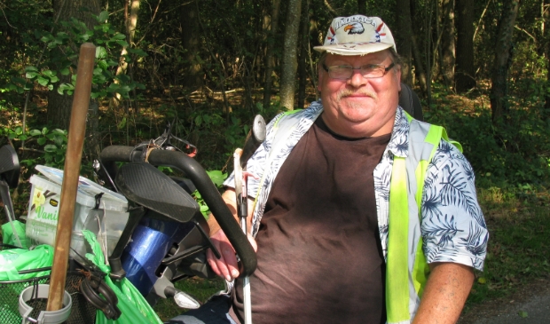 <p>Johannes Winkel op zijn scootmobiel in het groen.</p>