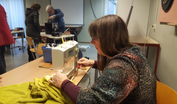 Vrijwilligster aan de slag achter de naaimachine.