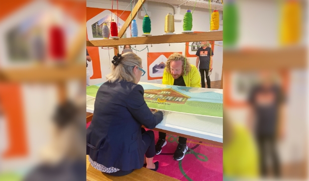Wethouder RO Mariëtte Sedee maakt de eerste steek van het Groeiend Groot Poldertapijt