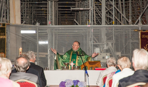 <p>Pastoor-deken Eugène Jongerden houdt na drie jaar weer een viering tussen de steigers van het schip in de St. Urbanuskerk van Bovenkerk.</p>