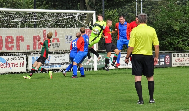 <p>WAVV-aanvaller Davey Jansen gaat de strijd aan met de doelman van Oranje Blauw.</p>