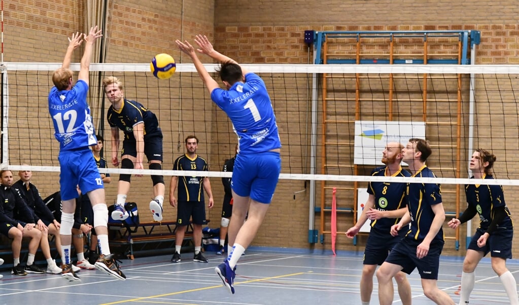 Mart van Leeuwen fileert de blokkering van Compaen. De volleyballer kan terugzien op een prima debuut in de topdivisie.