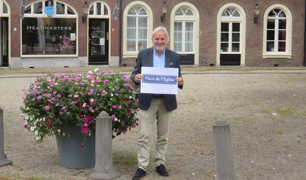 Bram Brinkman toont de nieuwe naam die het Kerkplein gedurende één middag zal dragen.