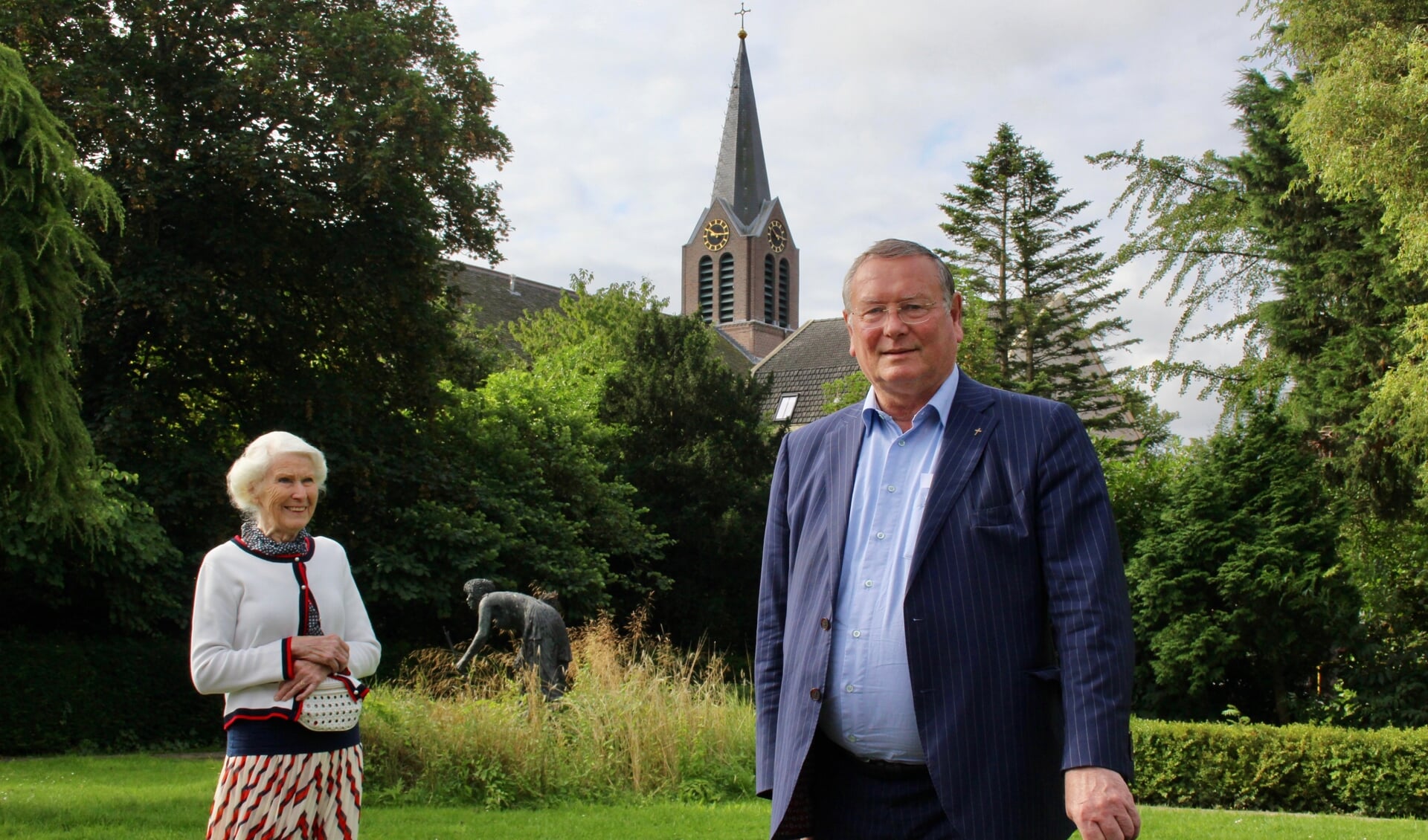 Pastoor Kees van Lent, samen met Grietje de Vries-Millenaar, in ‘zijn’ inmiddels landelijk bekende bijbelse tuin. 