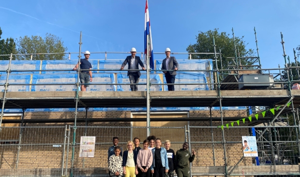 <p>wethouder Frank Berkhout en schooldirecteur Ronald Bouwman hesen de vlag onder toeziend oog van leerlingen van De Bloeiwijzer</p>
