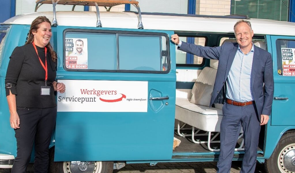 Wethouder Patrick Kiel van economische zaken poseert bij de 'vintage' Volkswagenbus'.