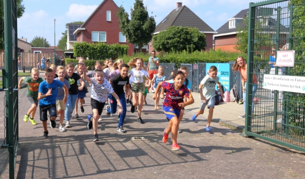 <p>De kinderen rennen het sportveld op. </p>