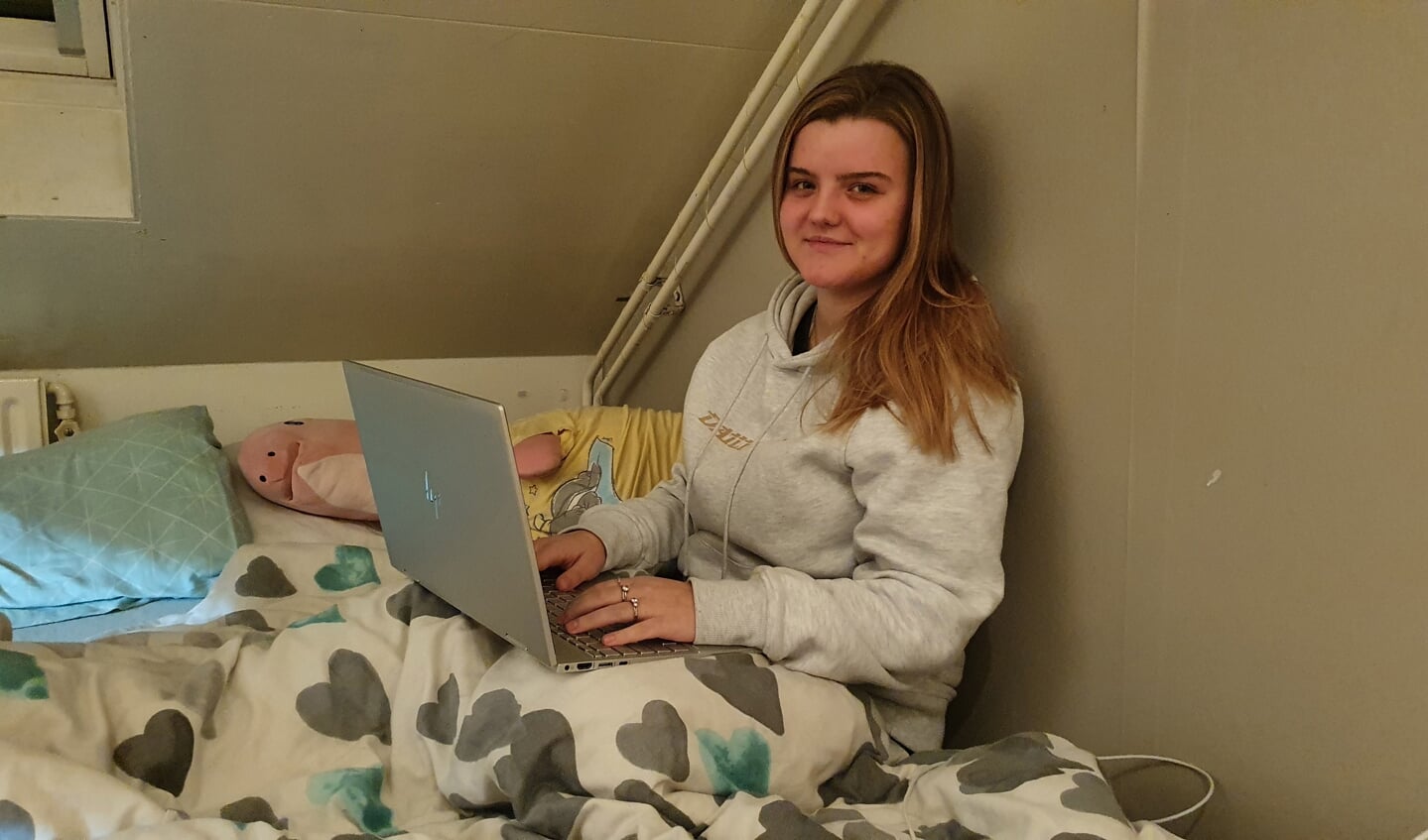Dewi-Noa in haar kamer. Zij kiest voor de warmte van haar dekbed tijdens het studeren.