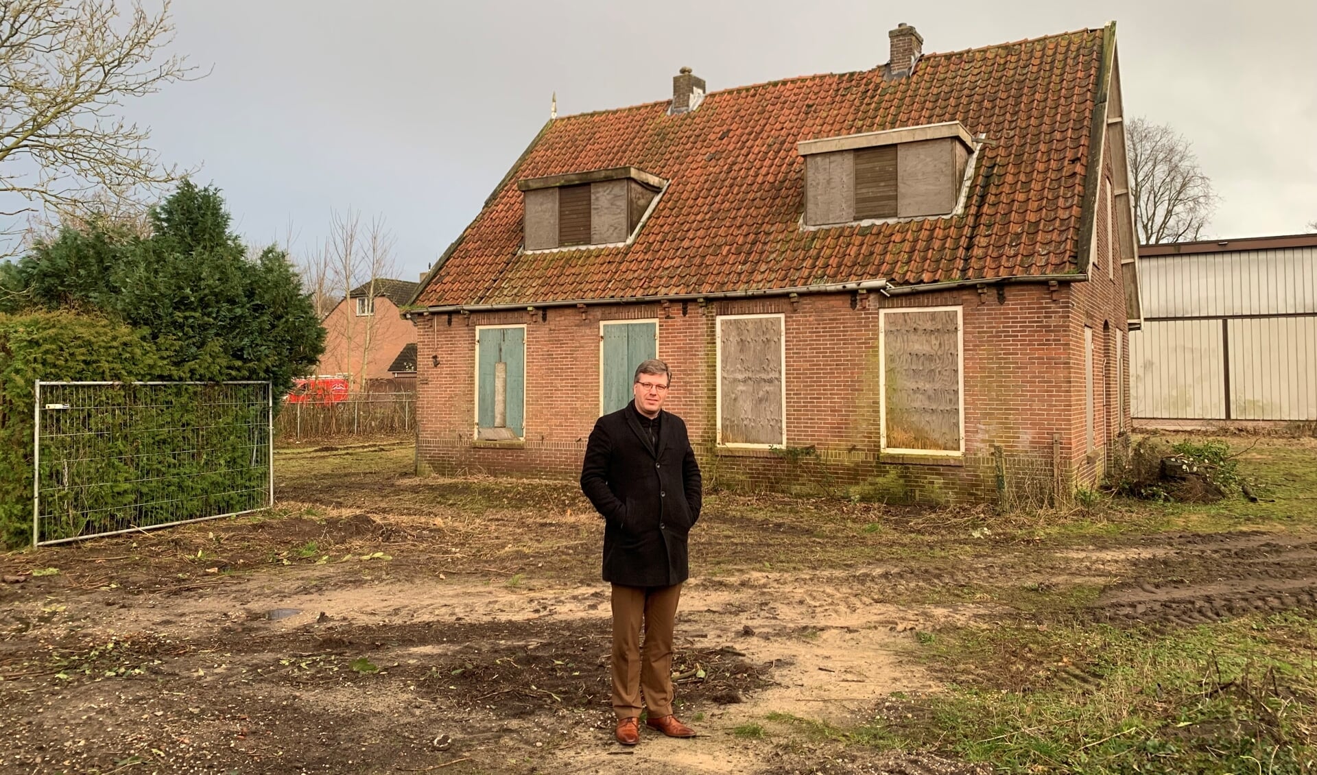 Scriba Wim Verweij voor de huidige onbewoonbare woning op het perceel van de kerk, die plaats zal maken voor de vijf nieuwe starterswoningen