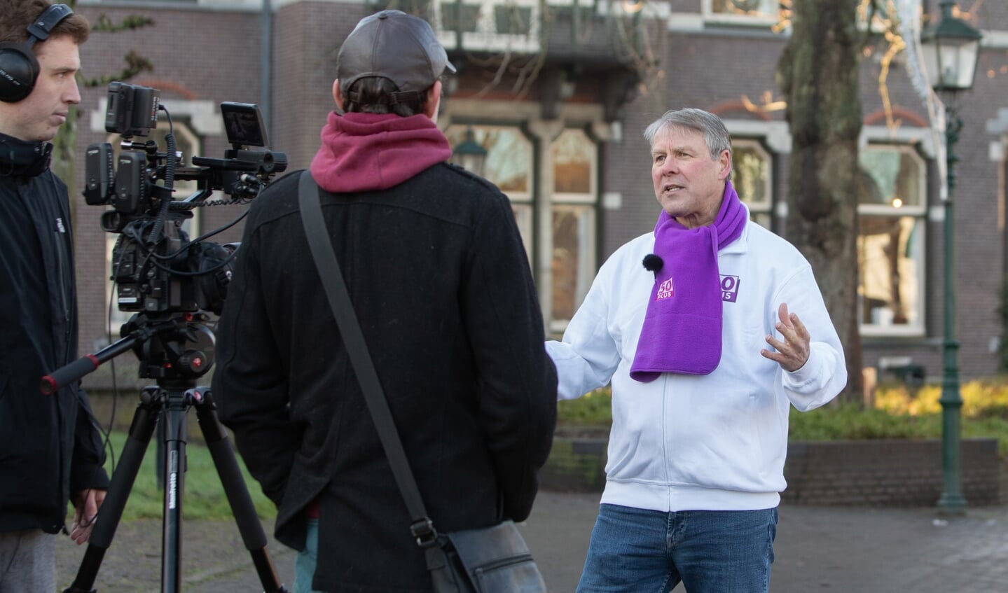 John van Loon met paarse 50Plus sjaal op de Brink. 