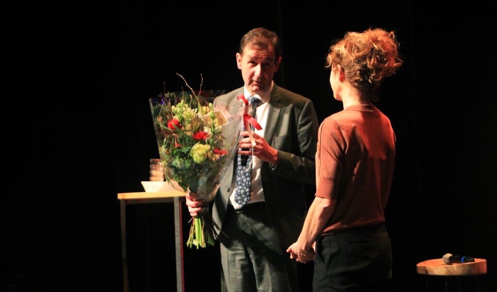 Gedeputeerde Rob van Muilekom overhandigt bloemen aan Barbara Wittebol, directeur Kunst Centraal, tijdens bijeenkomst Anders Denken. 