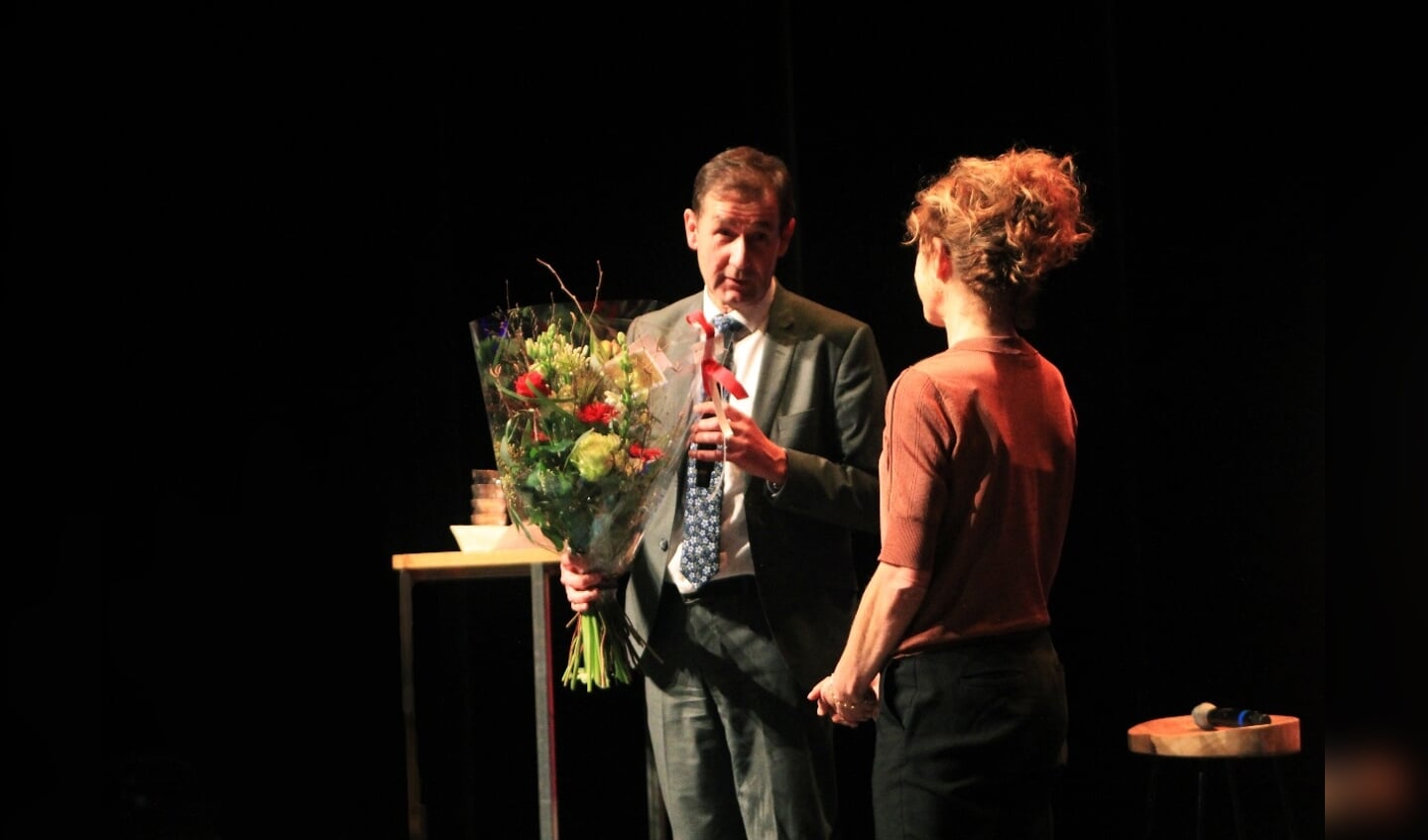 Gedeputeerde Rob van Muilekom overhandigt bloemen aan Barbara Wittebol, directeur Kunst Centraal, tijdens bijeenkomst Anders Denken.