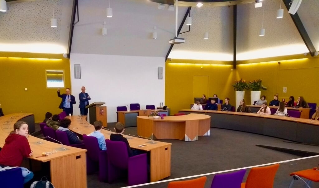 Leerlingen tijdens de Doe Dag in de raadszaal van de gemeente