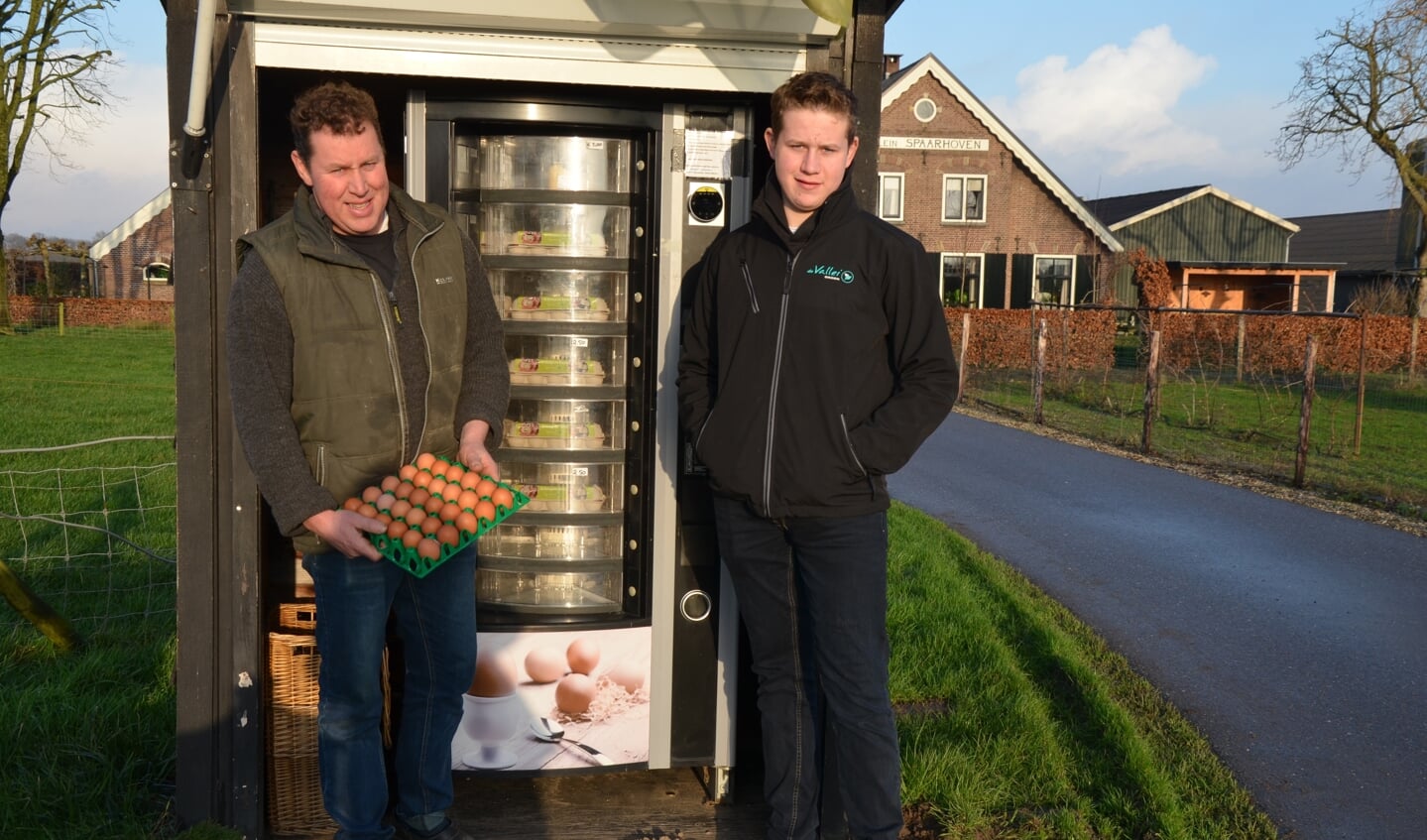 Evert Jan Veen en zoon Arjan bij de eierenautomaat onder aan de Rijndijk