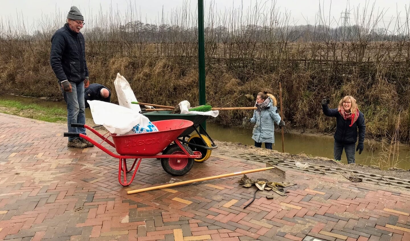 De bermen opruimen, de een gooit alles op de kant de ander mikt het in de kruiwagen, en brengt het naar de container