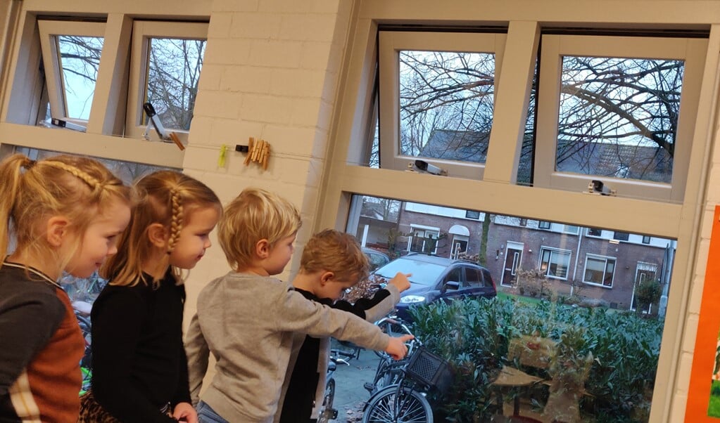 Leerlingen van de Willem van Oranjeschool kijken naar buiten; alle ramen staan open voor ventilatie.
