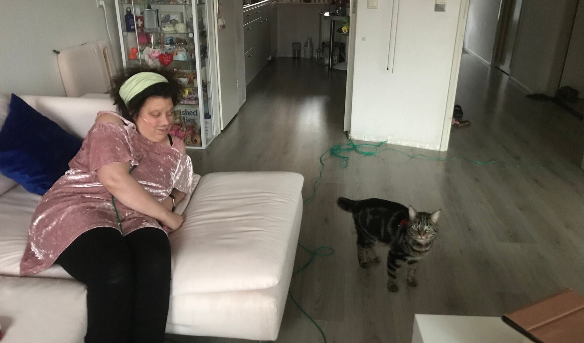 Rachel Schelleman, die afhankelijk is van de toediening van zuurstof, en haar kat Gizmo in hun verduurzaamde huurwoning.