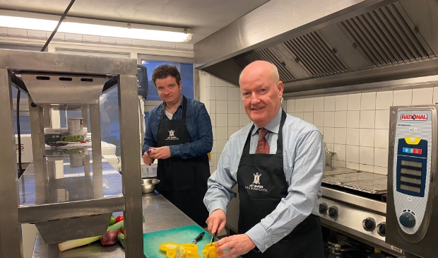 Burgemeester Ruud van Bennekom kwam Jasper Dorresteijn van het Wapen van Werkhoven helpen met het snijden van groeten.