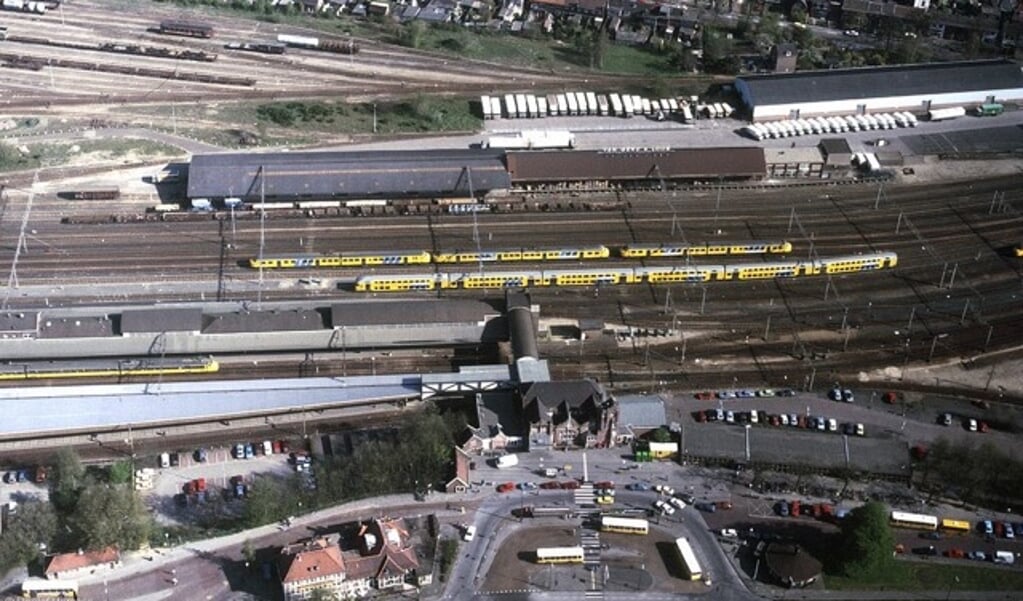 Een luchtfoto station Amersfoort met boven de treinen het complex Van Gend en Loos.