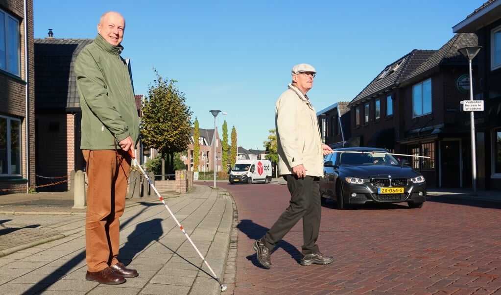 Adriaan van 't Wout (links) en Leen Droogendijk steken over bij de Schoutenstraat in Barneveld.