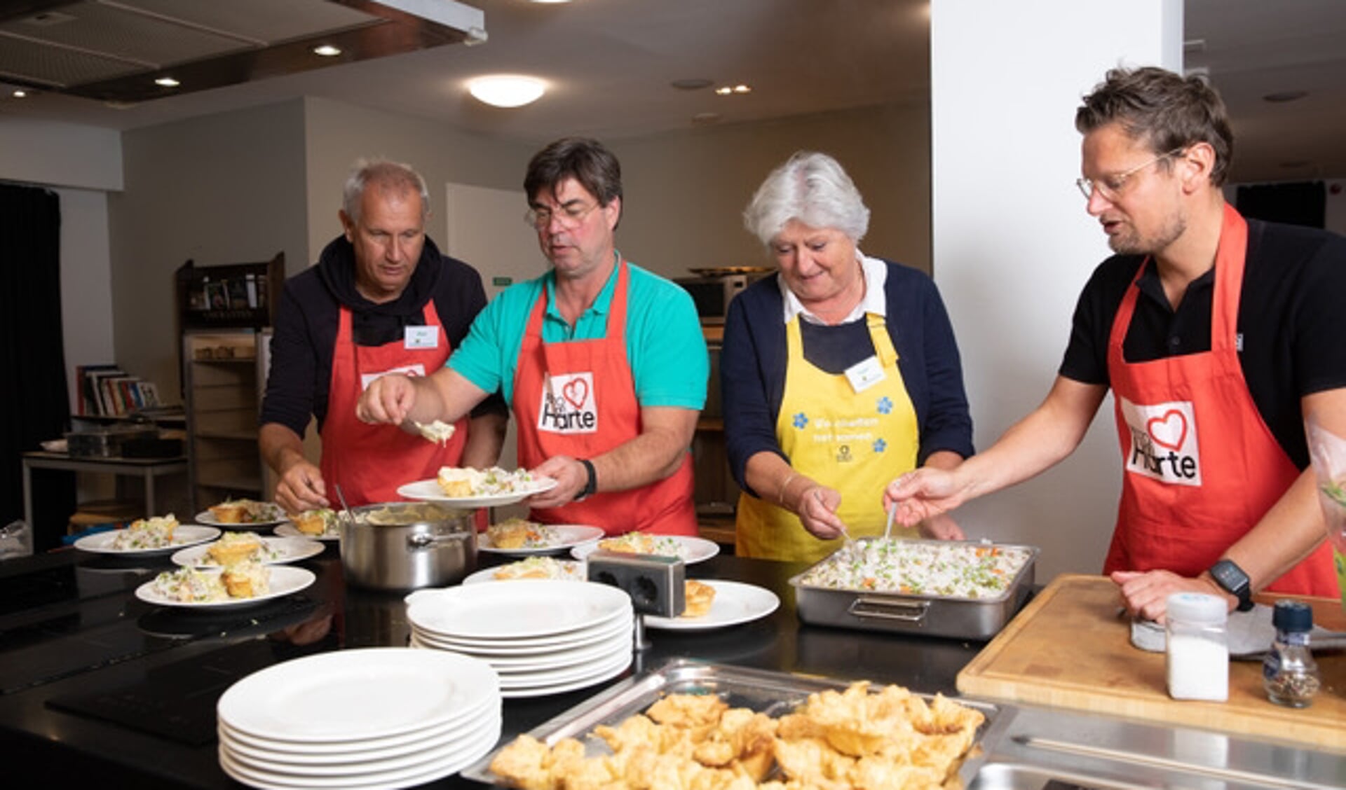 Mensen met beginnende dementie koken samen met hun mantelzorger een driegangenmenu.