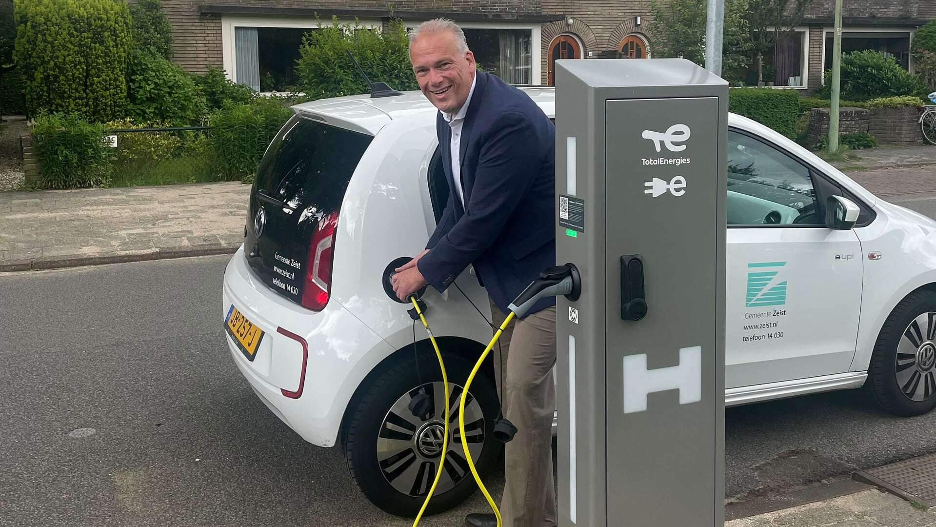 Wouter Catsburg steekt de stekker in een elektrische auto van de gemeente Zeist.