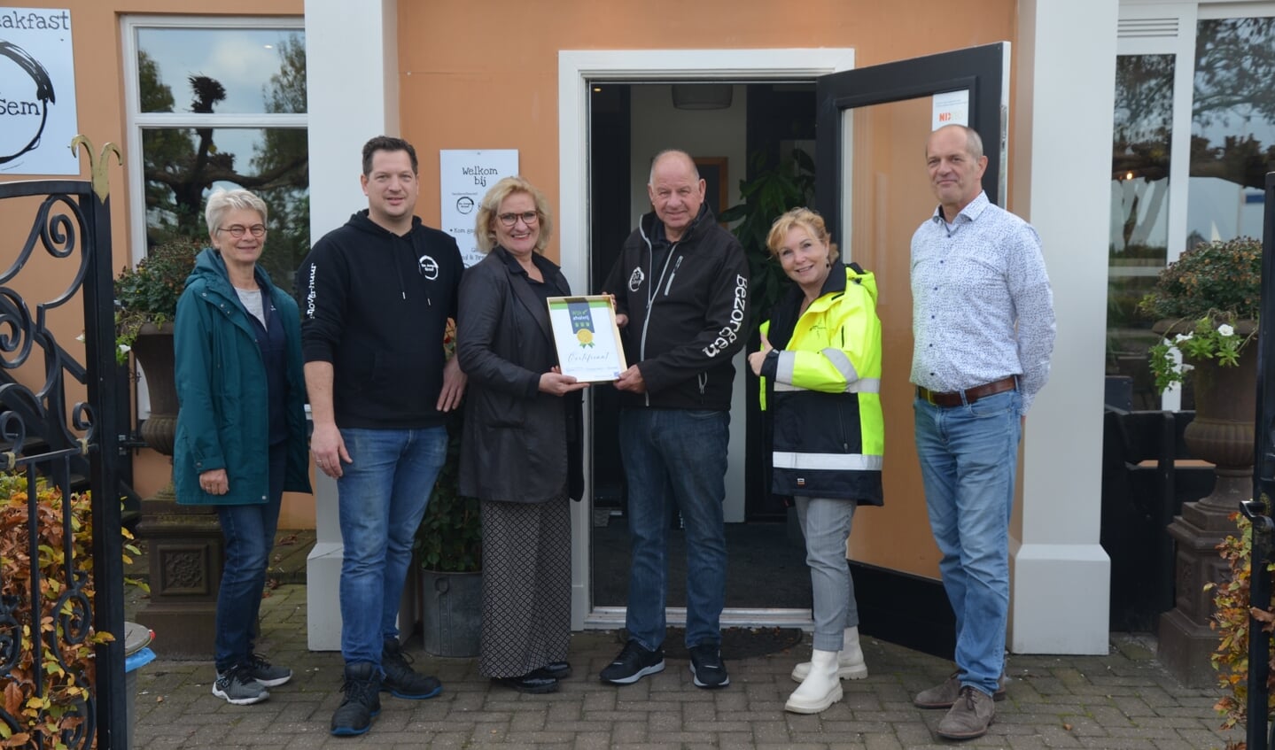 Wethouder Wil Koserman overhandigt het certificaat aan Patrick Terschegget en Terschegget sr.