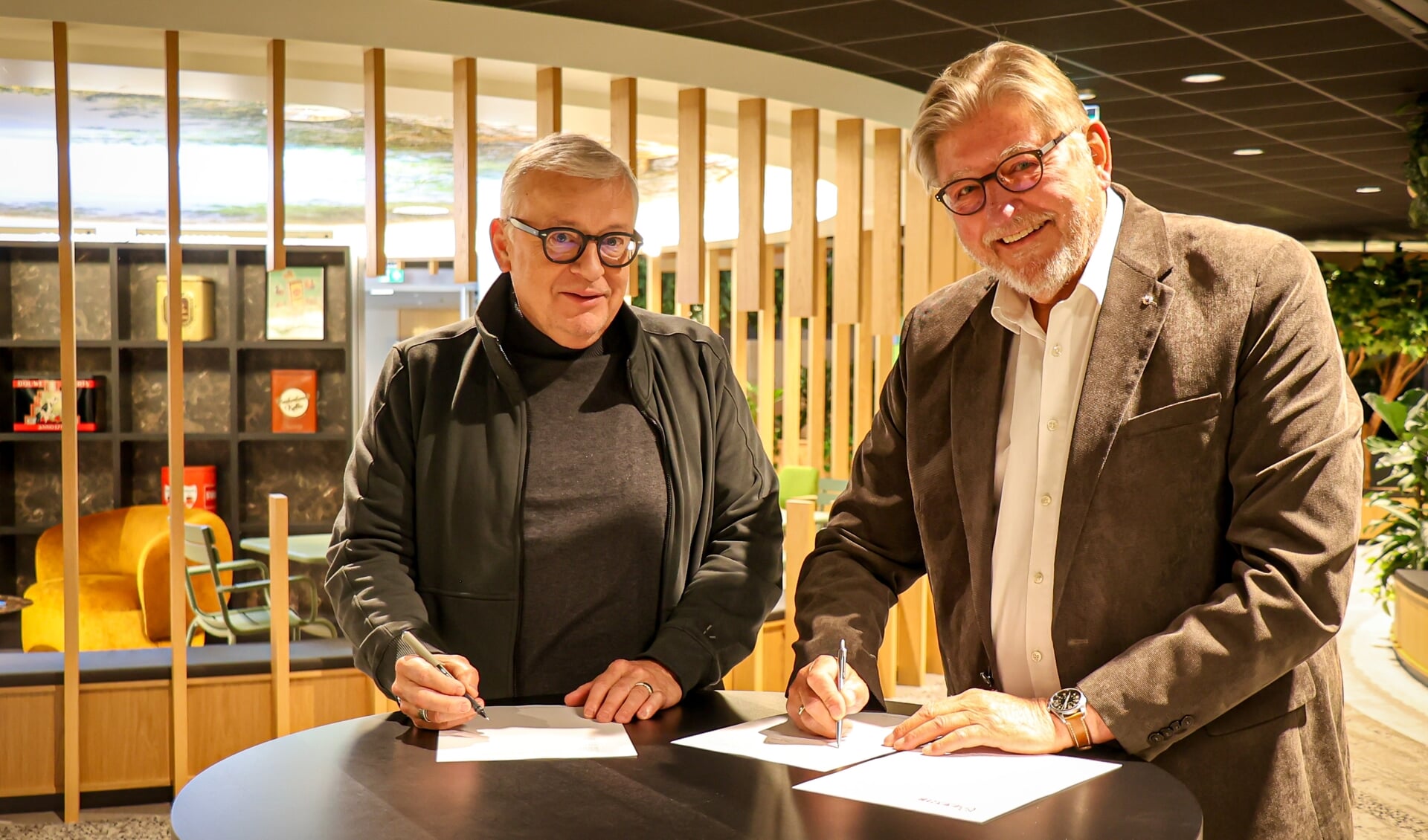Peter de Groot (l) en Peter le Cuivre ondertekenen de fusieovereenkomst tussen AAN! en RTVA.