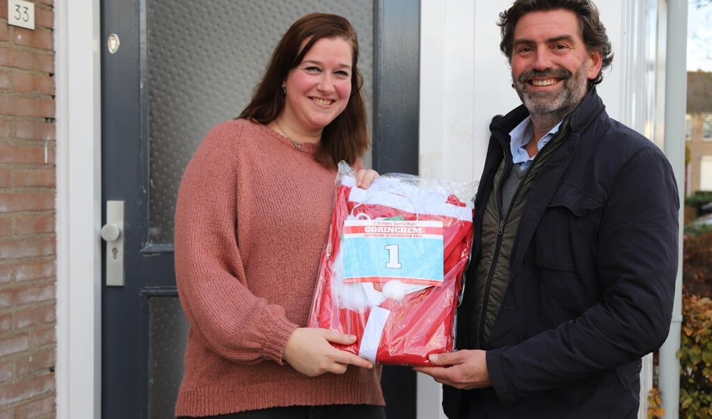 Prijswinnares Priscilla Sleeuwenhoek krijgt haar pak overhandigd van Frank Visch (voorzitter Rotary Santa Run)