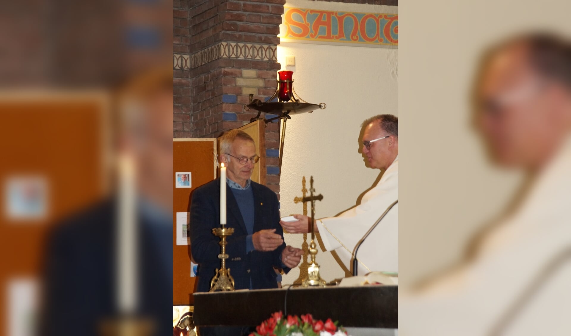 Hans van Blokland ontvangt de Willibrordplaquette van pastoor Harrold Zemann.
