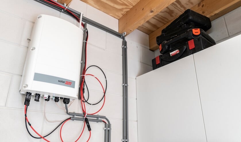 De omvormer voor de zonnepanelen hangt in de garage.