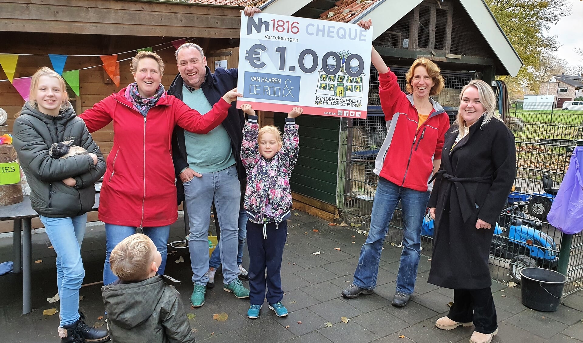 Laura van Haaren (uiterst rechts) overhandigt namens Van Haaren & De Roo Financieel Adviseurs in Renkum een cheque van € 1000,00.